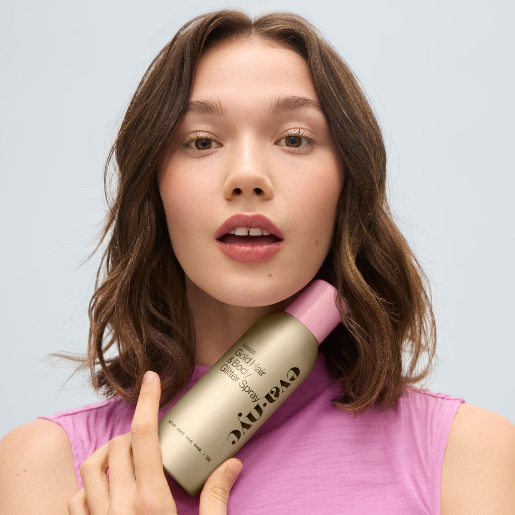 Model holding Kweeen Gold Hair & Body Glitter Spray 